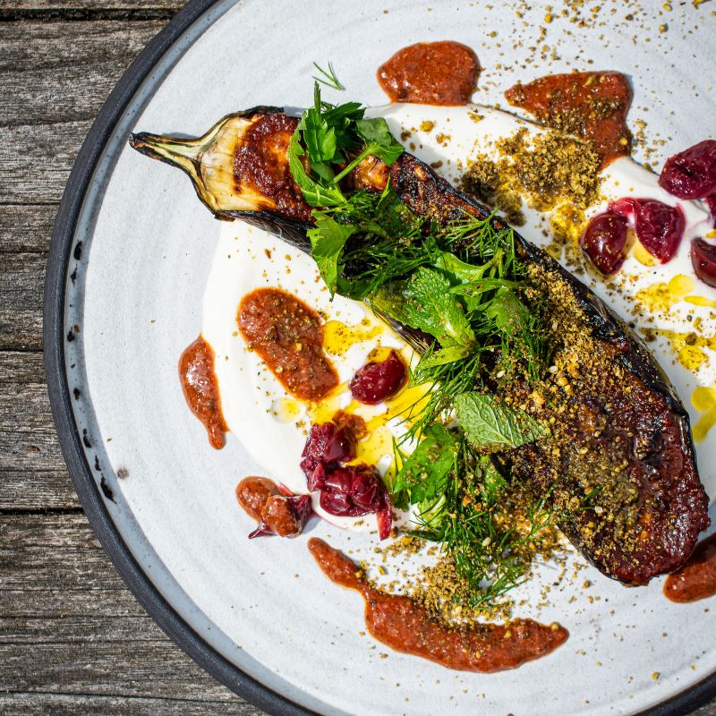 Gegrillte Aubergine mit Joghurt, frischen Kräutern und Sauerkirschen, verfeinert mit Harissa Gewürz der Gewürzmühle Rosenheim