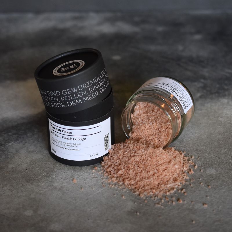 Pink salt flakes – offenes Gewürzglas mit Gewürzdose daneben