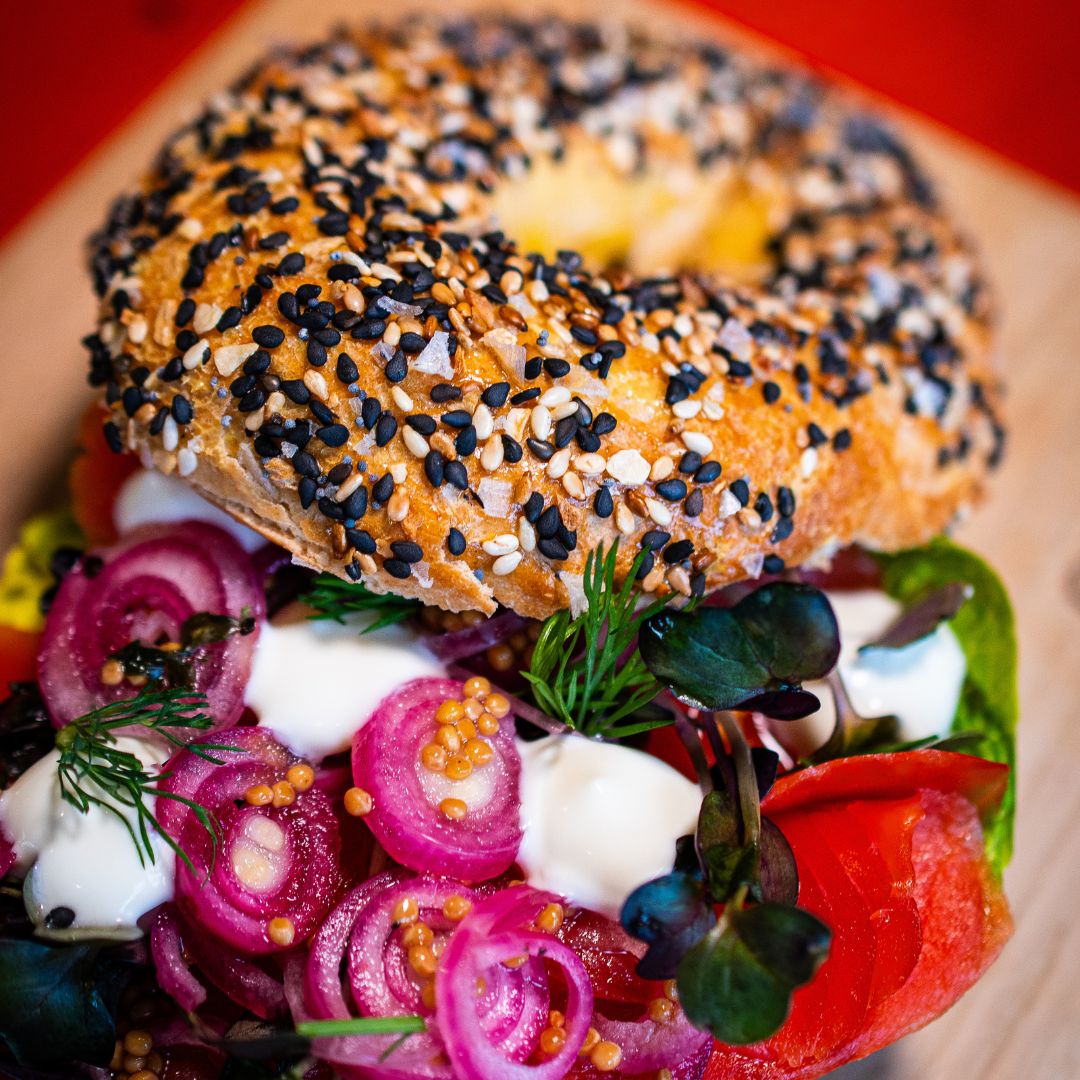 Belegter Bagel mit Salat, eingelegten roten Zwiebeln, Kräutern, cremigem Dressing und Everything Bagel Gewürz aus der Gewürzmühle Rosenheim