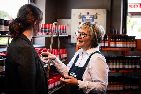 Eine freundliche, ältere Verkäuferin im Beratungsgespräch mit einer Kundin.
