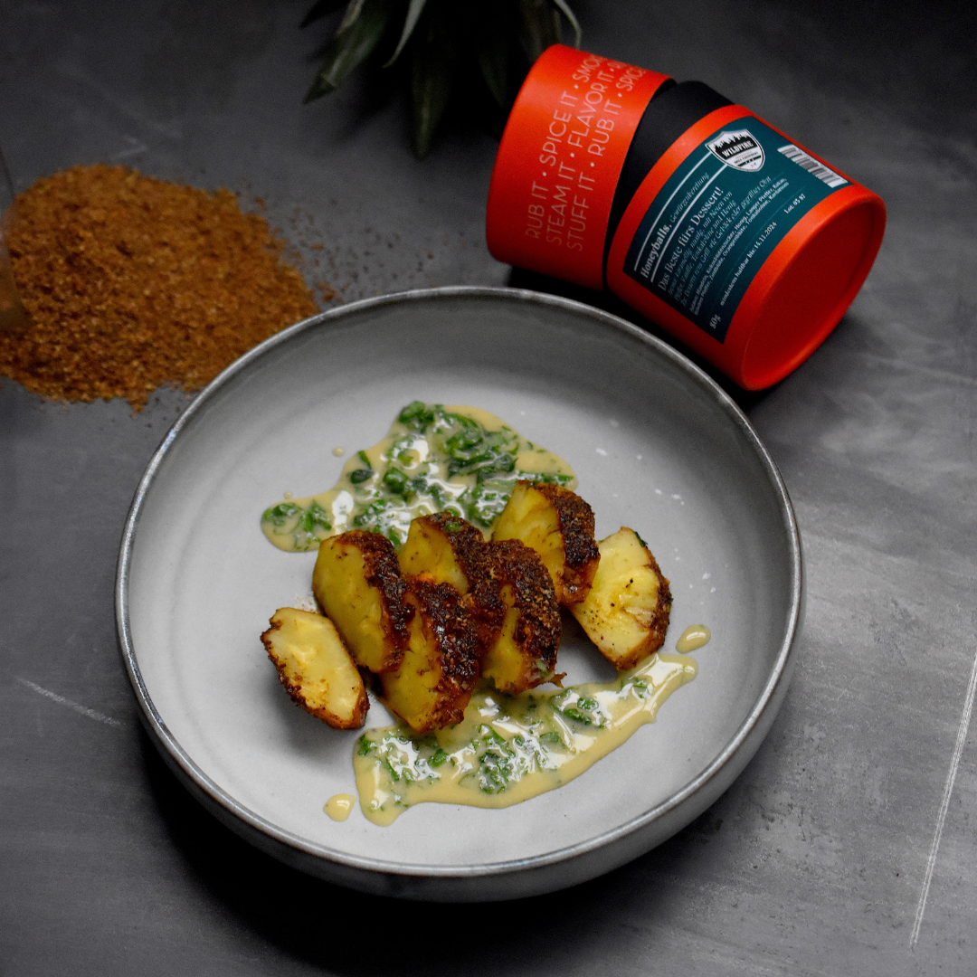 Gegrillte Ananas auf Teller serviert, mit Honeyballs Gewürz verfeinert - daneben umgekippte Gewürzdose