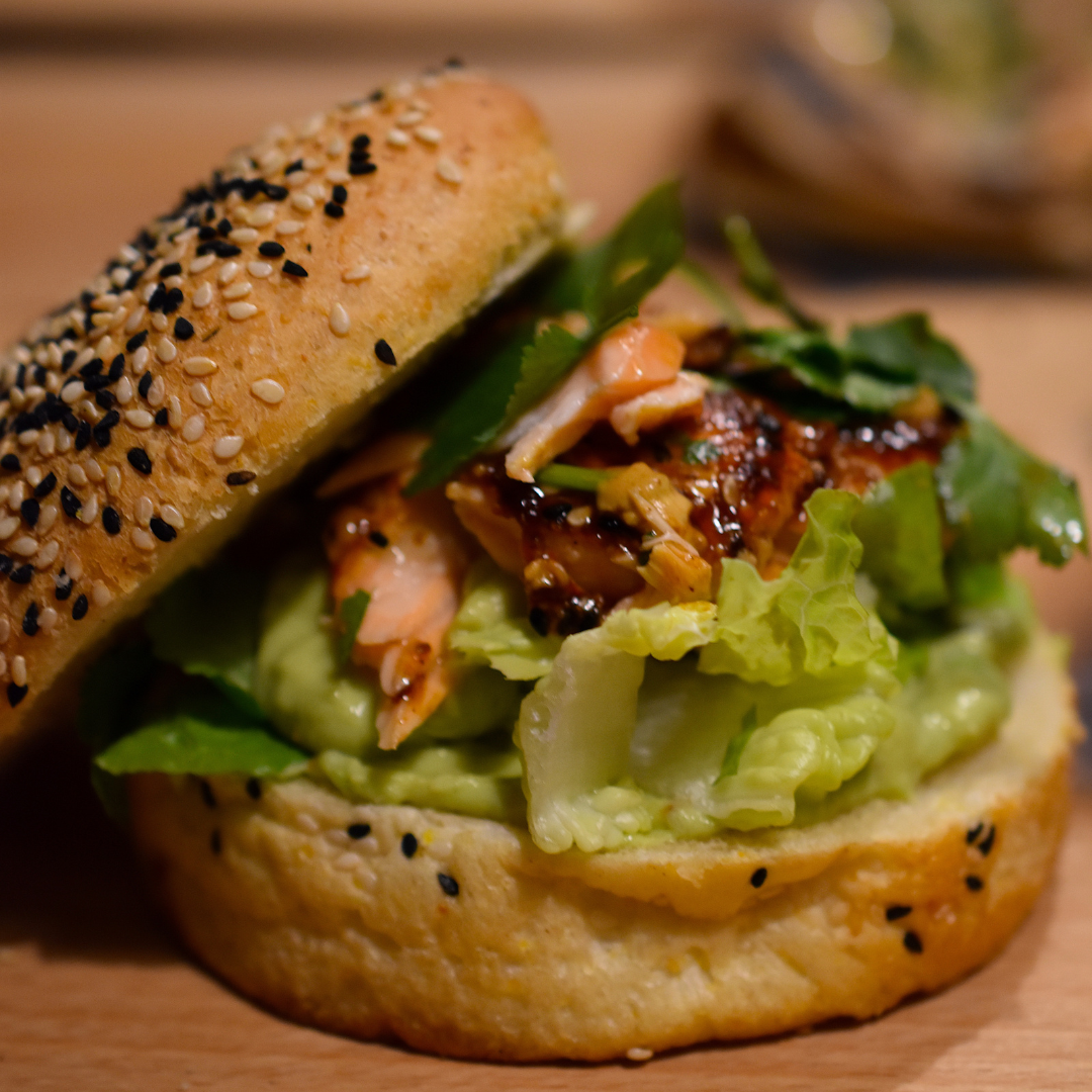 Bagel mit Lachs und Salat, gewürzt mit Sauce, Szechuan Teriyaki Sauce