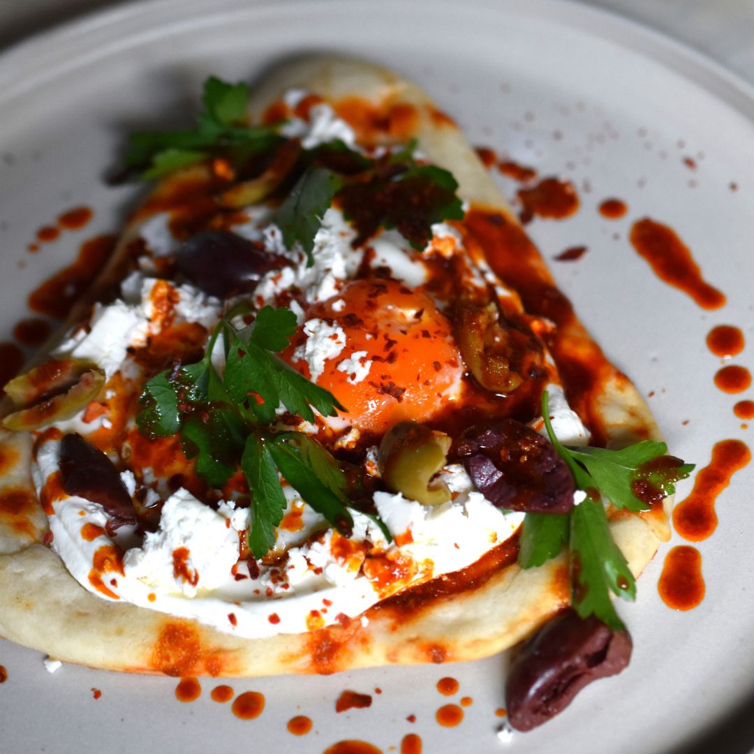 Nahaufnahme türkische Eier auf einem Teller verfeinert mit Pul Biber.