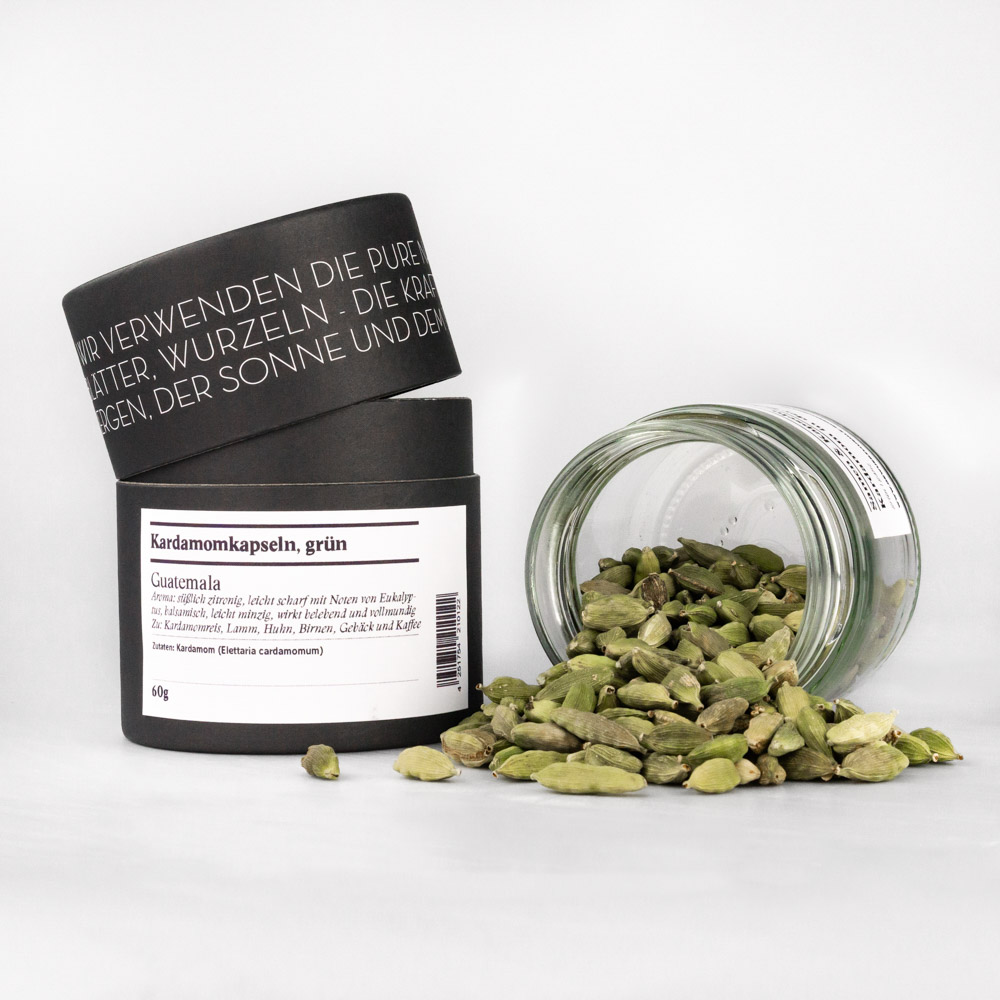 Kardamom in der Schale grün, ganz – offenes Gewürzglas mit Gewürzdose daneben