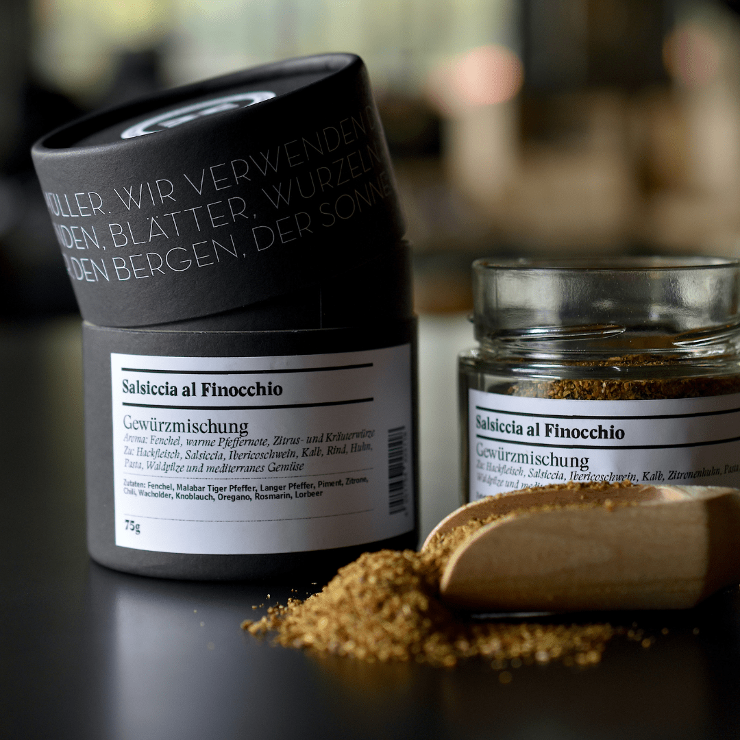 Salsiccia al Finocchio Gewürzmischung - Gewürzdose und offenes Glas, Holzschaufel im Vordergrund
