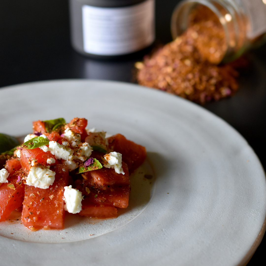 Wassermelonen Salat gewürzt mit Rosenharissa, serviert auf einem Teller