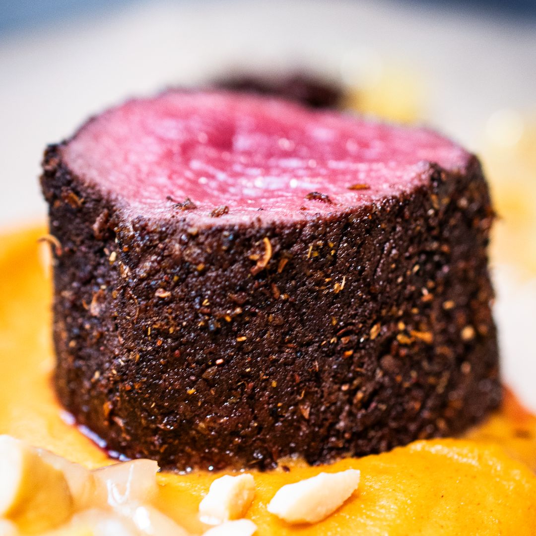 Nahaufnahme Stück Rehrücken mit einer Gewürzkruste aus Five Spice Gewürz aus der Gewürzmühle Rosenheim in einer Portion Süßkartoffelstampf.